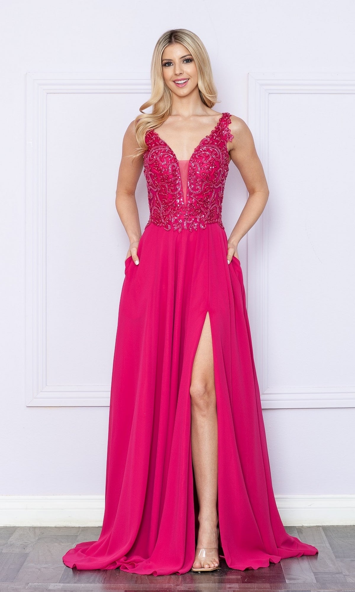A woman stands against a light wall wearing the magenta Beaded-Bodice Long A-Line Prom Dress 9366, featuring a sleeveless lace bodice, front slit, pockets, and elegant prom-ready style.